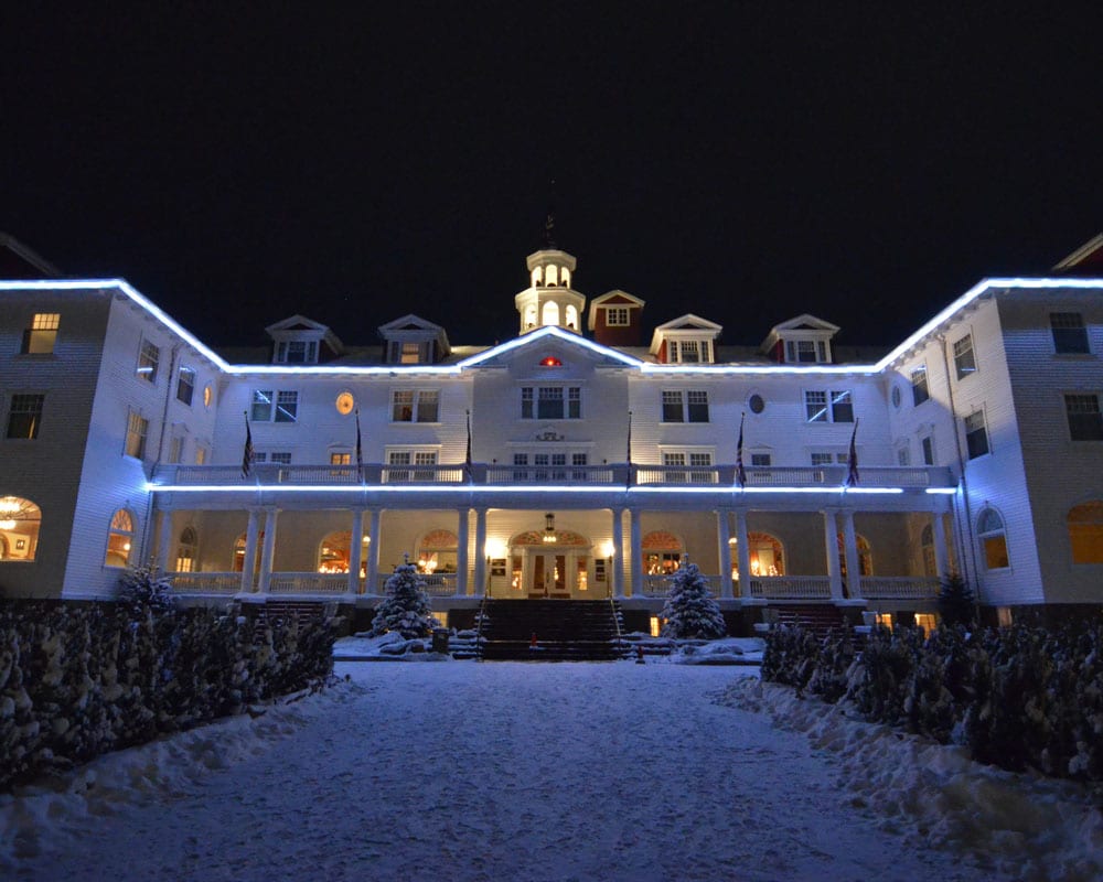 Outside of the Stanley Hotel in winter with snow on the ground.