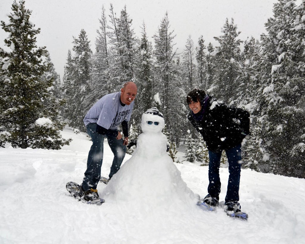 Brooke and Buddy building a snowman in Rocky Mountain National Park in May during their honeymoon and first visit to Colorado