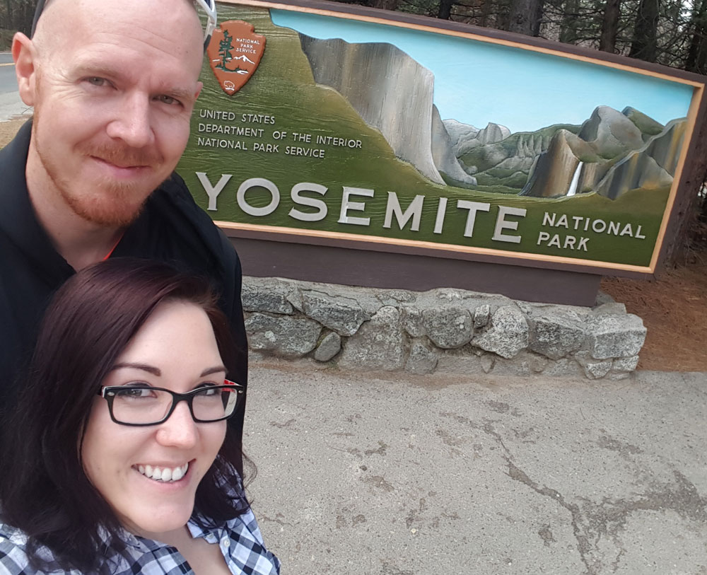 Brooke and Buddy next to the Yosemite National Park sign
