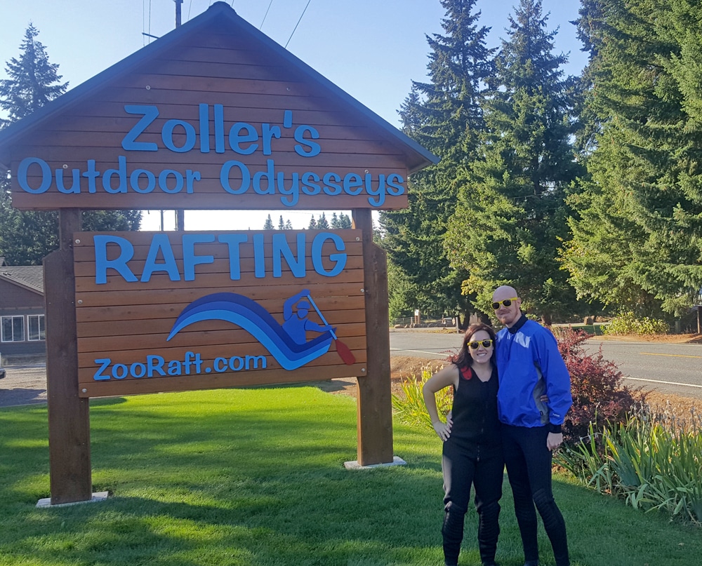 Brooke and Buddy posing in front of the Zoller's Outdoor Odysseys sign with their gear on