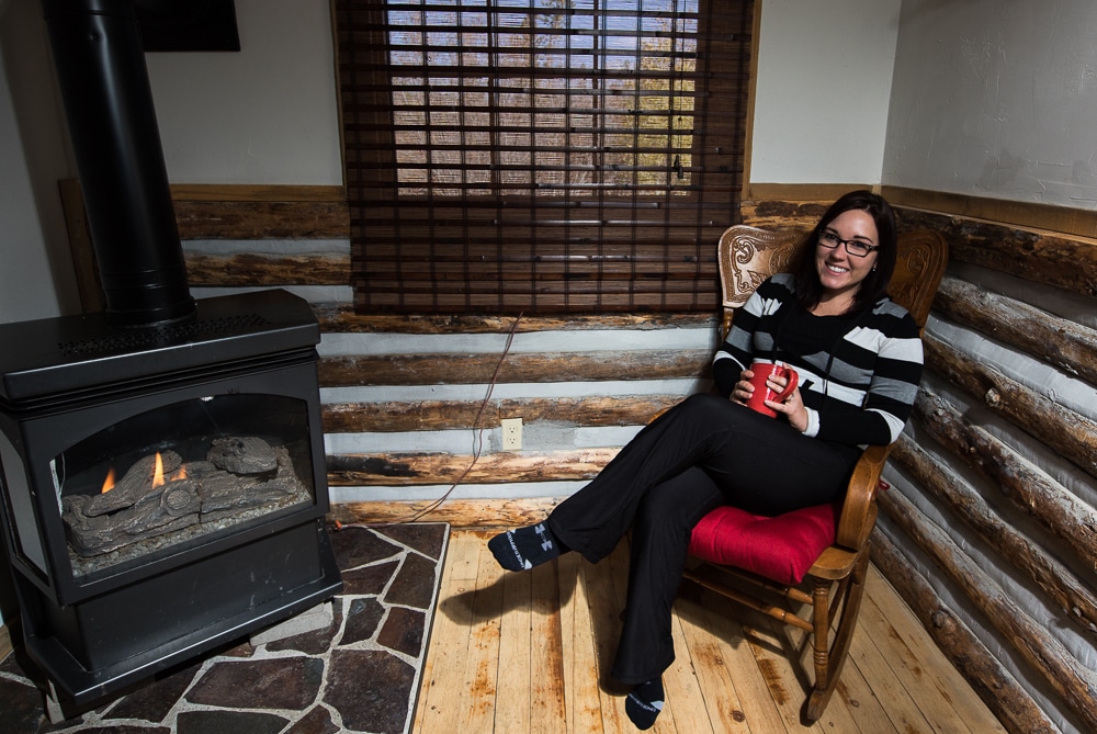 Brooke sitting by the fire sipping coffee in our Grand Lake Cabin