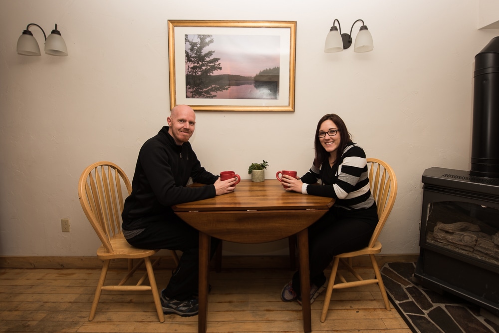 Brooke and Buddy sitting at the table while sipping coffee at their Grand Lake Cabin Rental
