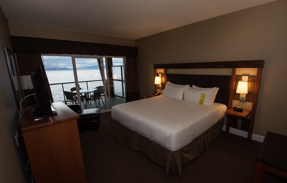 A large comfortable bed in the middle of our room with large sliding glass doors leading to balcony