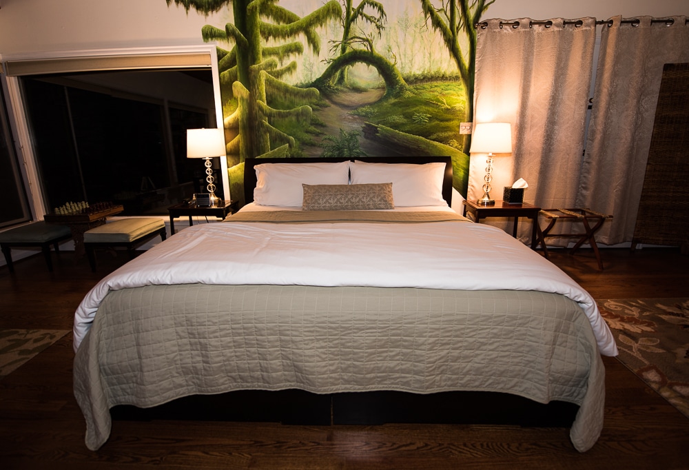 Lovely king bed, with beautiful artwork behind it in the Hoh Rainforest Suite at Domaine Madeleine