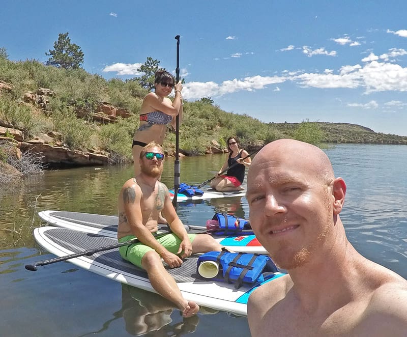 Brooke and Buddy paddleboarding with their friends on Horsetooth Resoivior in Fort Collins Colorado