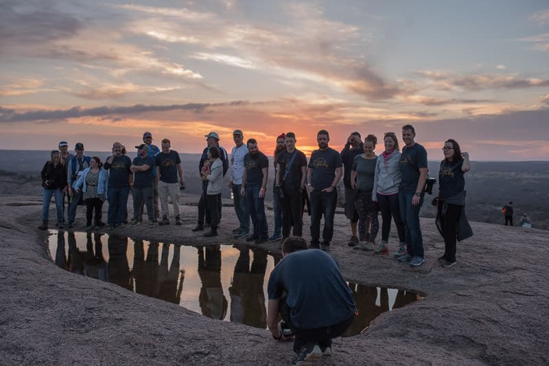 Kyle Kesterson taking a group photo using the reflection of a pool of water