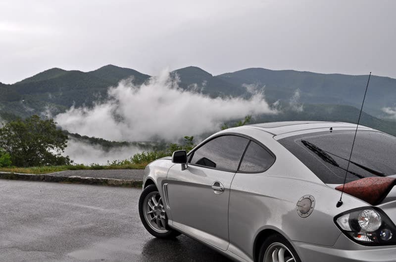 Buddy's old Hyundai Tiburon on the blue ridge parkway in North Carolina with clouds off in the distance