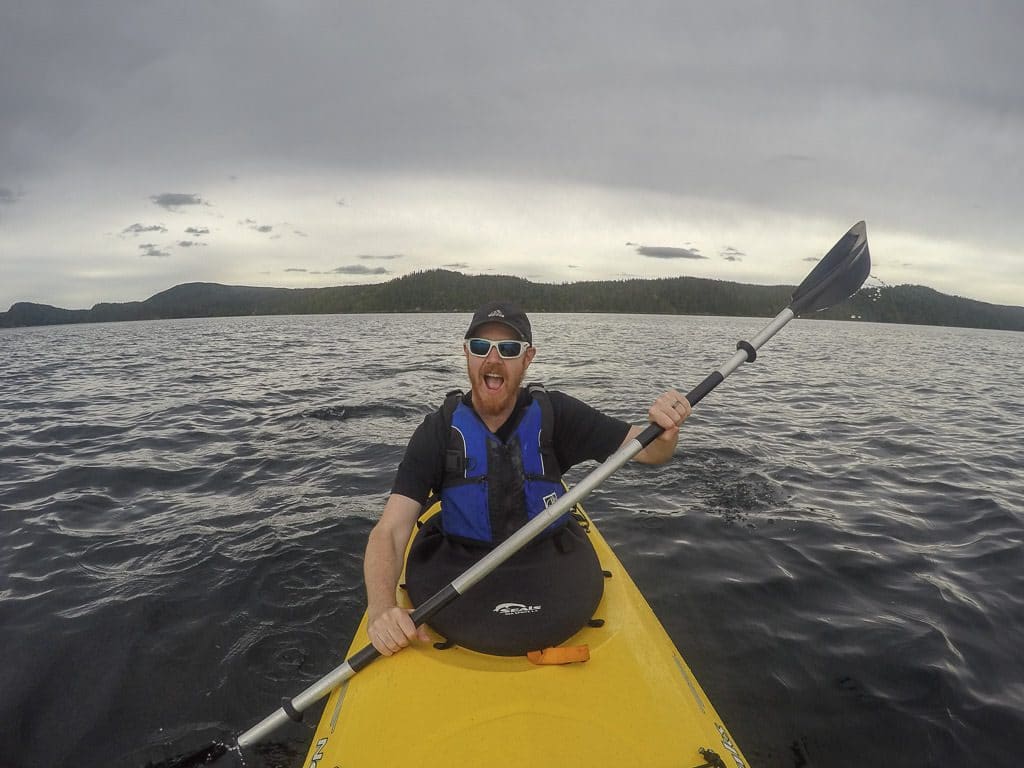 Buddy paddling in the waters of Terra Nova National Park on a very cloudy and gloomy day