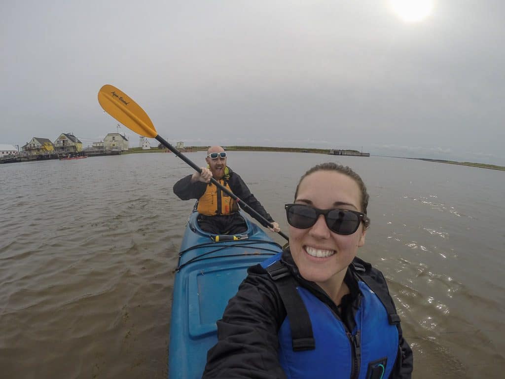 Brooke smiling and taking a selfie while Buddy paddles while kayaking