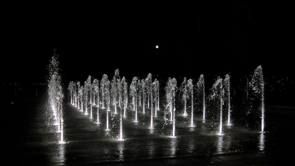 Fountain at night with the water lit up