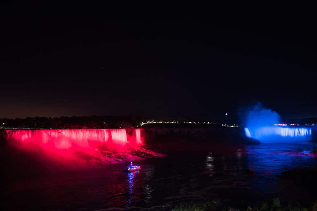 Niagara Falls lit in red and blue at night
