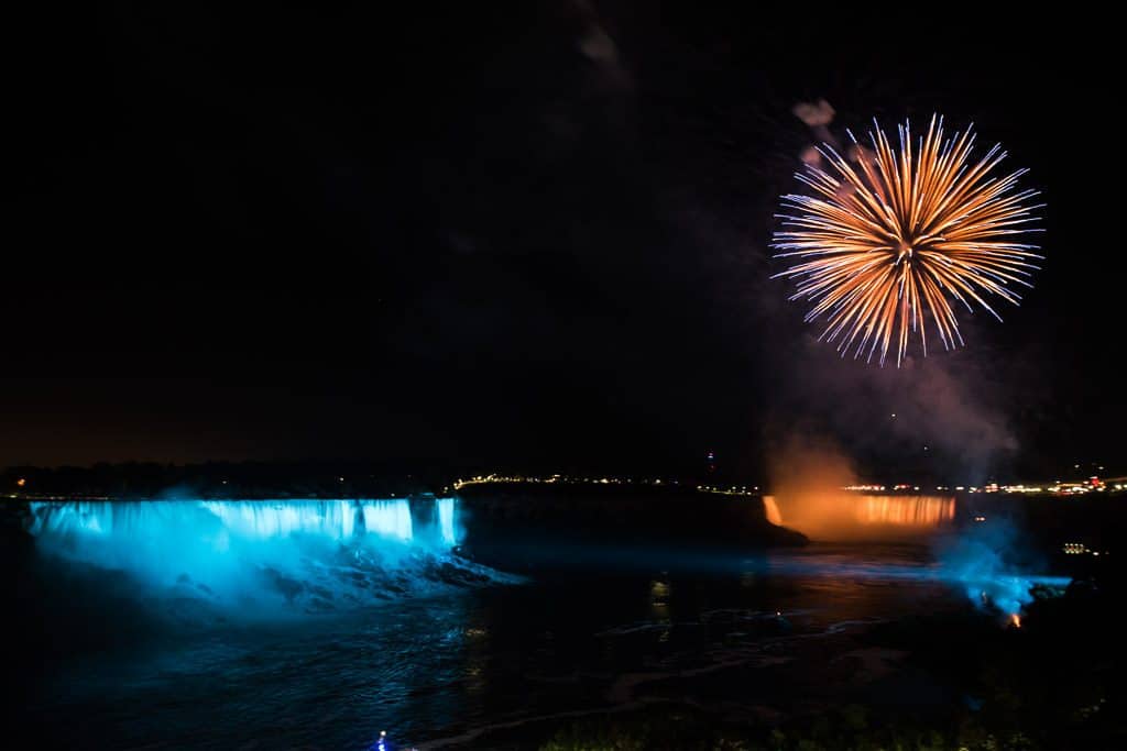 Blue and Orange Firework over a Blue and Orange Niagara Falls at night