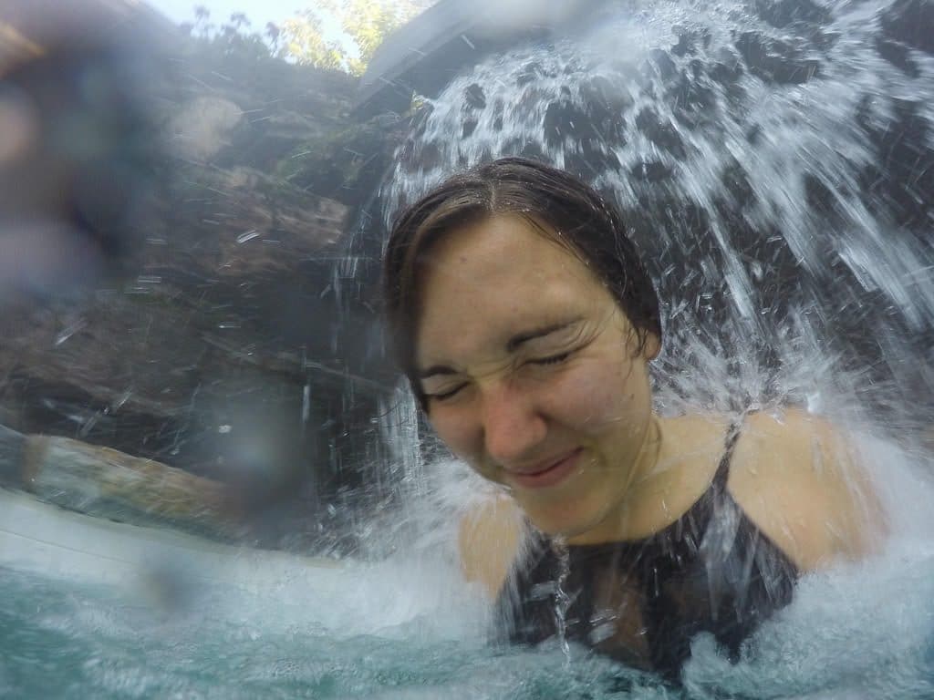 Brooke letting the water pressure from the waterfall beat down on her shoulders to help alleviate the pent-up stress at scandinave spa in mont-tremblant