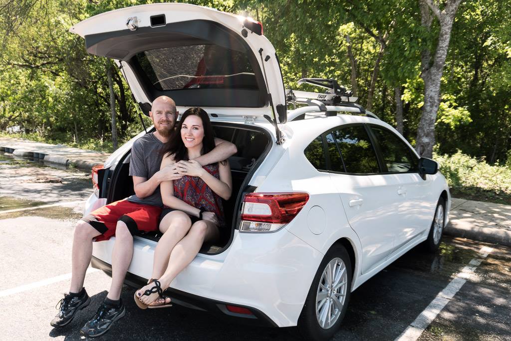 couple sitting in a subaru to travel by house sitting after deciding to stop full-time RVing