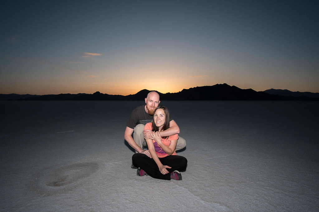 Brooke and Buddy at the bonneville salt flats as the sun sets behind them