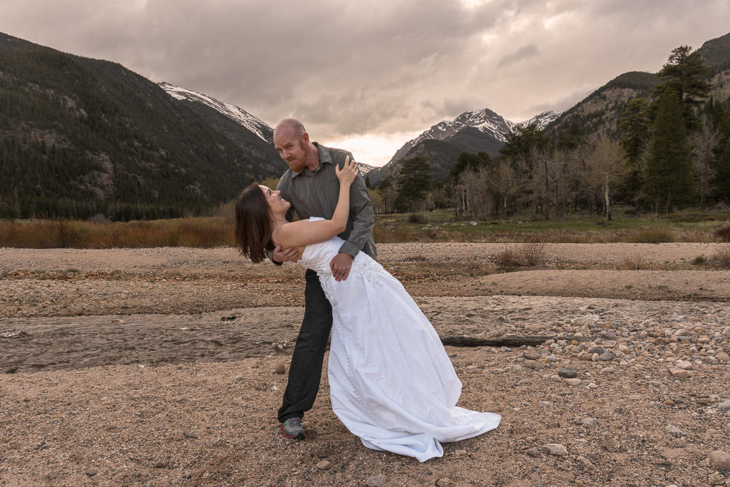 couple dipping in front of mountains on rocky mountain vow renewal