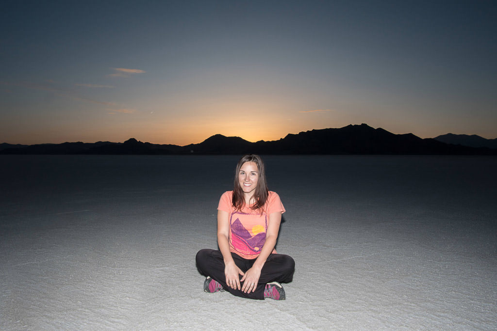 Brooke sitting on the salt at Bonneville Salt Flats during sunset