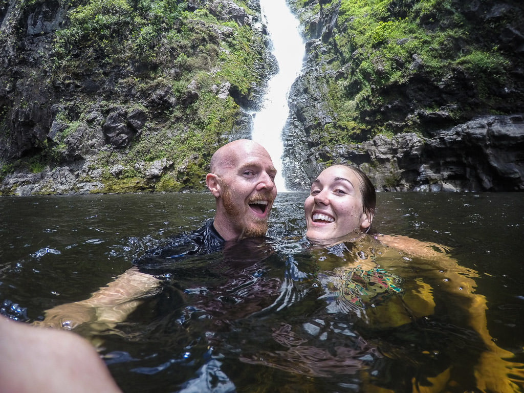swimming under a waterfall at halawa valley in molokai