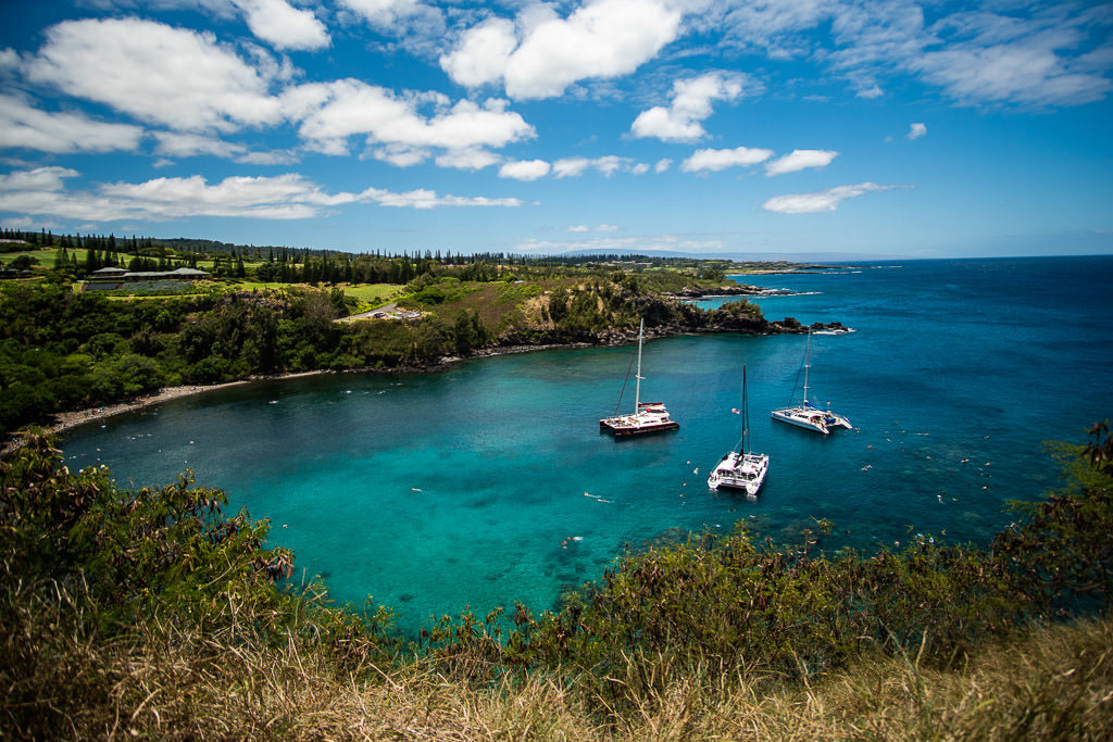 Crystal blue water and 3 large boats sitting in Honolua Bay where we watched snorkelers and sea turtles swim below