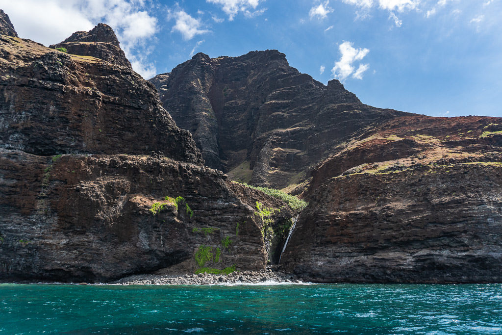 mini waterfall with scenic views on napali coast boat tour in Kauai