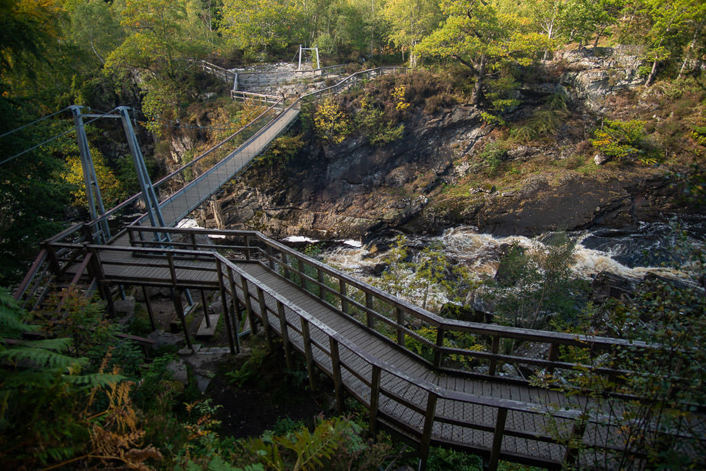 The bridge and pathway that leads to a gorgeous overlook looking down onto Rogie Falls in Scotland