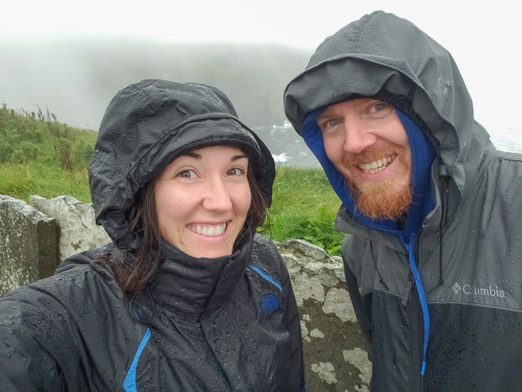Brooke and Buddy next to the Cliffs of Moher in all their rain gear