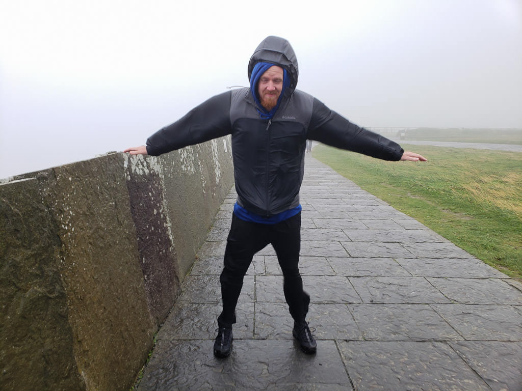 Buddy leaning into the wind during our windy, rainy and foggy adventure to the Cliffs of Moher