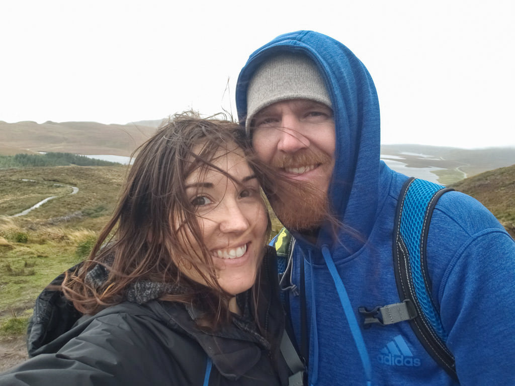 Brooke and Buddy taking a photo in the Isle of Skye on a very windy day
