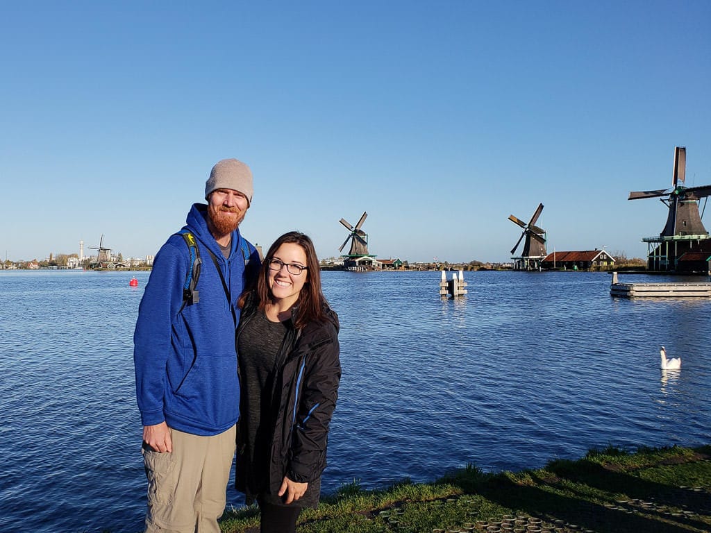 standing in front of windmills in zaane schans on day trip from amsterdam to holland's countryside