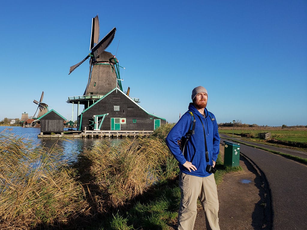 posing in front of windmill in zaane schans on day trips from amsterdam to holland's countryside