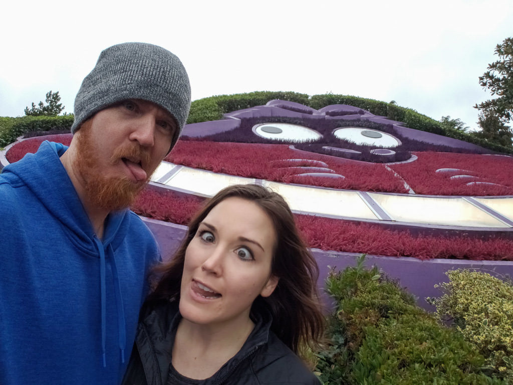 Brooke and Buddy making funny faces in front of the Cheshire Cat flower garden in the Alice in Wonderland area of disneyland paris