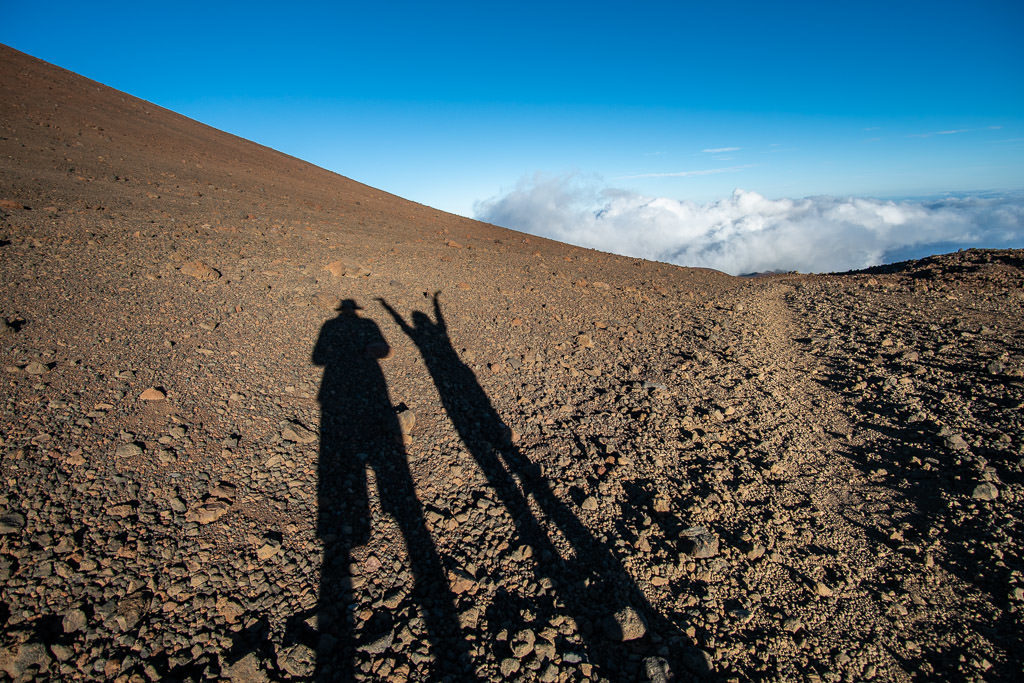 couple shadows at mauna kea summit sunset