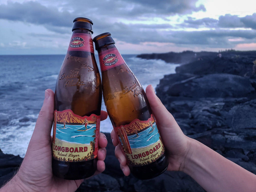 uncle roberts night market pahoa hawaii with beers at the rocky beach at sunset