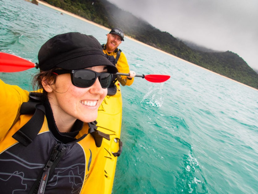 couple taking a selfie while kayaking in Mosquito Bay in Abel Tasman National Park
