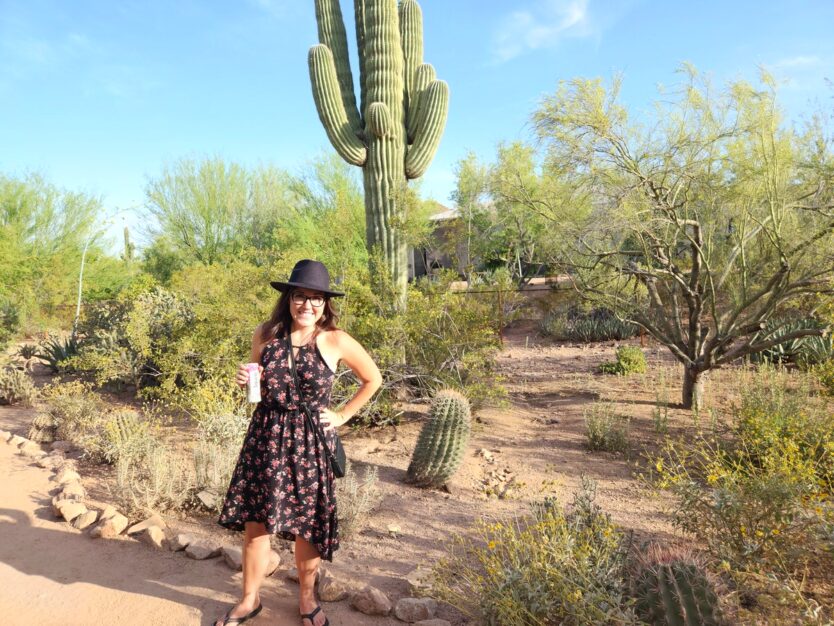 standing under a tall cactus at desert botanical garden